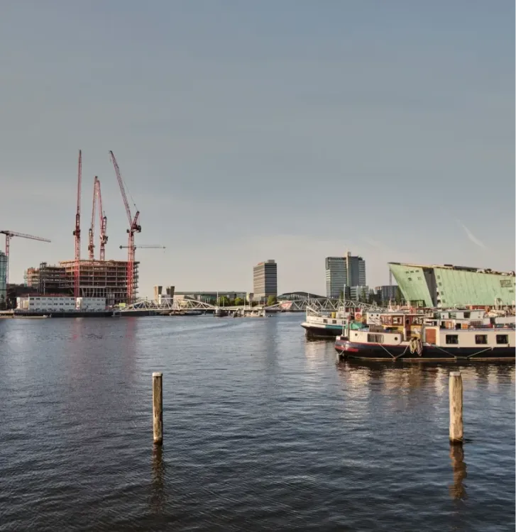 Bouwkranen langs het water in Amsterdam